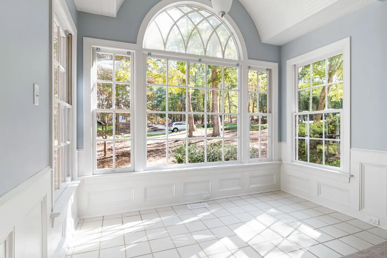 Bright room with white wainscoting, window casing and an arched window